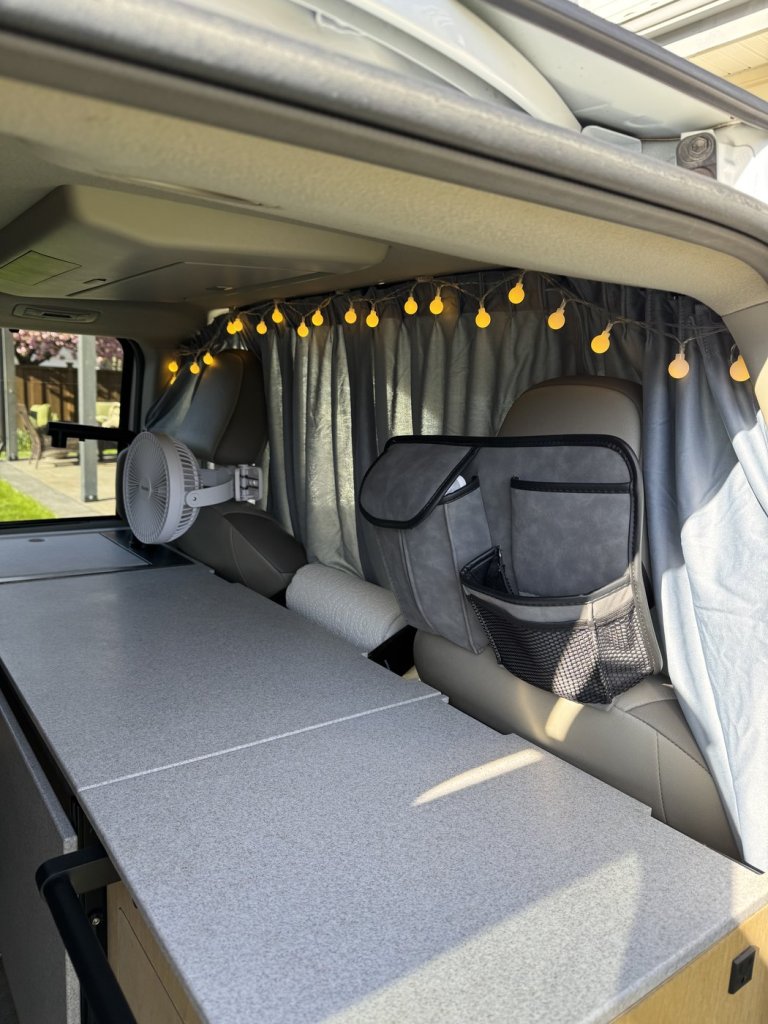 Side view of the closed divider curtain separating the front seats from the living area of a Toyota Sienna minivan camper